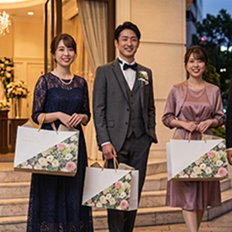 引き出物の紙袋を手に持ったパーティーの参加者