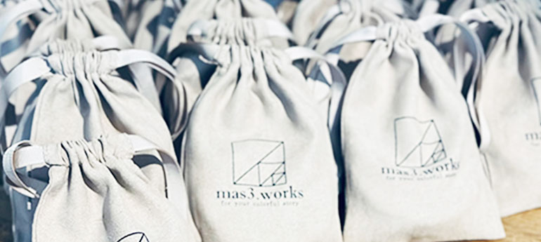 白色でダブル紐タイプのオリジナル巾着が多数写っている画像