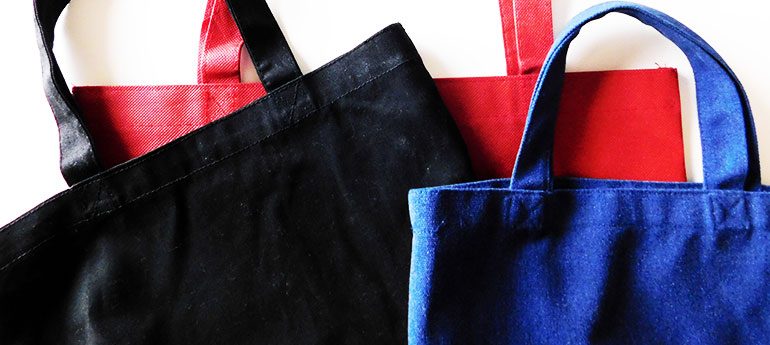 黒・赤・青色のサイズの異なるのトートバッグが写っているイメージ画像