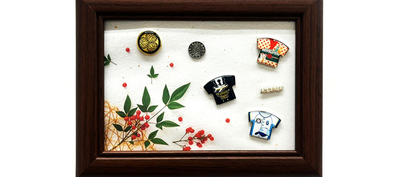 ディスプレイした5つのピンバッジを額装した画像