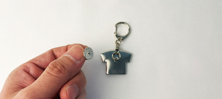 シャツの形をしたオリジナルピンバッジの裏面の留め具にシルバーのキーホルダーパーツの輪っかを通している画像