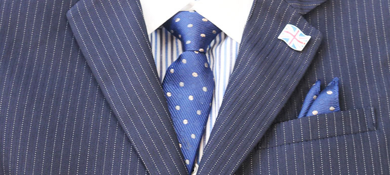 スーツのジャケットにピンバッジ（ラぺルピン）を装着しているコーディネート術のイメージ画像