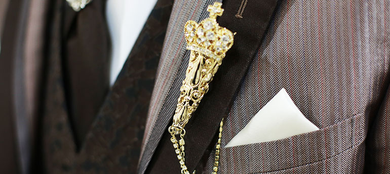 豪華でおしゃれな見た目の、スティックタイプのピンバッジ（ラぺルピン）をスーツに装着しているイメージ画像