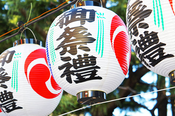 お祭りの会場で装飾されている、円筒形（丸型提灯）のオリジナル提灯のイメージ画像