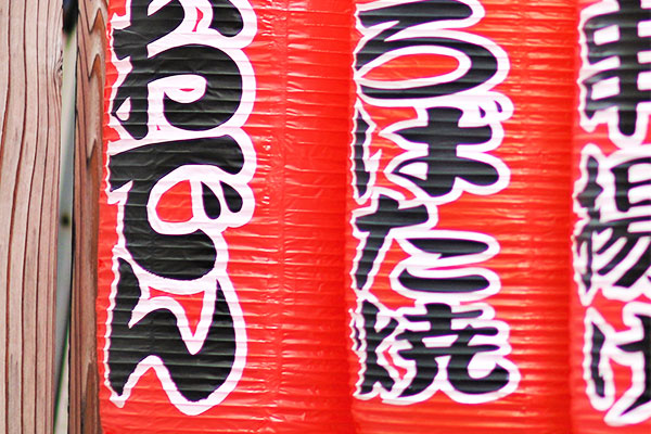 飲食店の入り口に装飾されている、おでん・ろばた焼・串揚げの文字が名入れされている赤提灯のイメージ画像