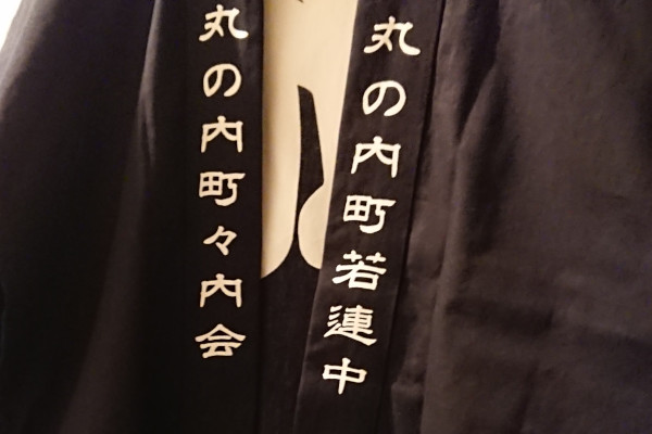 衿部分に町内会名と若連中の文字がプリントされた黒い法被のイメージ画像