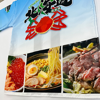 腰部分に海鮮丼、味噌ラーメン、ジンギスカンの拡大写真が並ぶデザイン