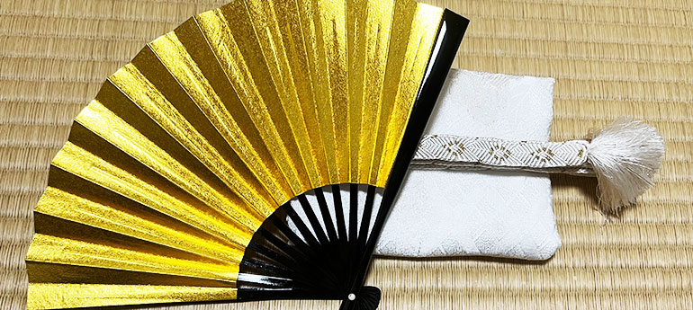 和装の結婚式で新婦や親族が使用する、骨部分が黒い漆塗りで扇面が金色の祝儀扇（末広）のイメージ画像