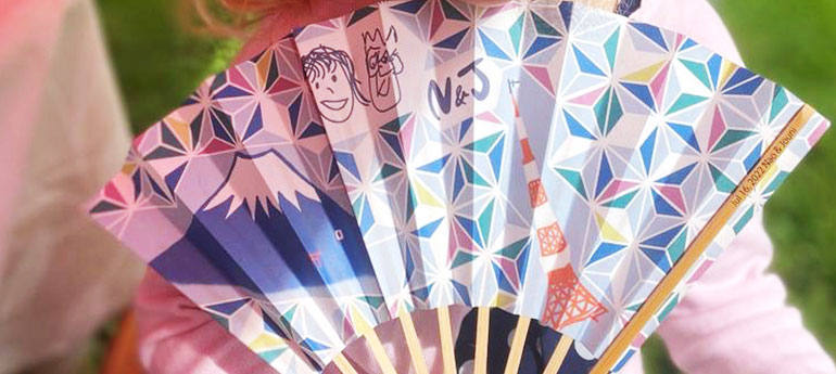 新郎新婦のお子さんが描いた2人の似顔絵をプリントして作った、引き出物用のオリジナル扇子のイメージ画像