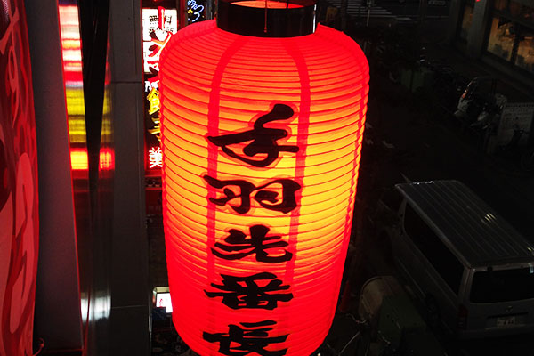 店名が名入れ印刷され、お店の外観にお店の看板として設置されている、オリジナル赤提灯のイメージ画像