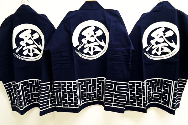 反応染めをした、天竺木綿・10番天竺・シャークスキン綿の3着の法被がハンガーに掛けられて並んでいる画像