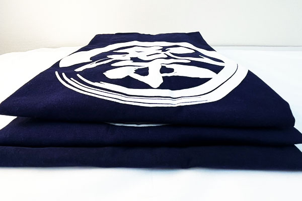 反応染めをした、天竺木綿・10番天竺・シャークスキン綿の3着の折りたたんだ法被が重なって並んでいる画像